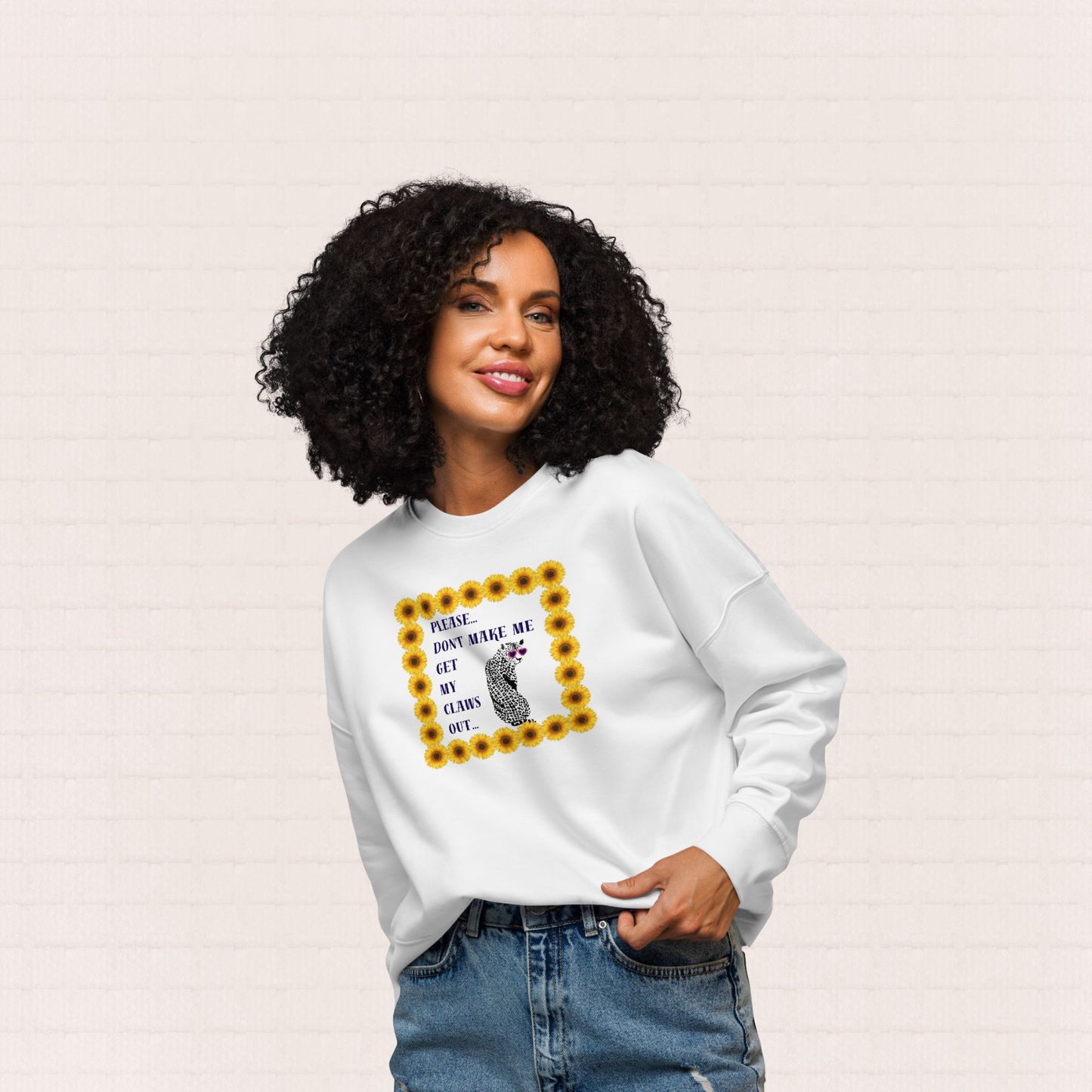 Womena wearing white sweatshirt with graphic of a leopard wearing sunglasses with text "Please.... Don't make me get my claw out" inside a sunflower border